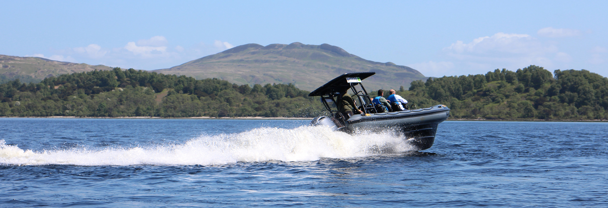 Group on humber speedboat with mountain in background