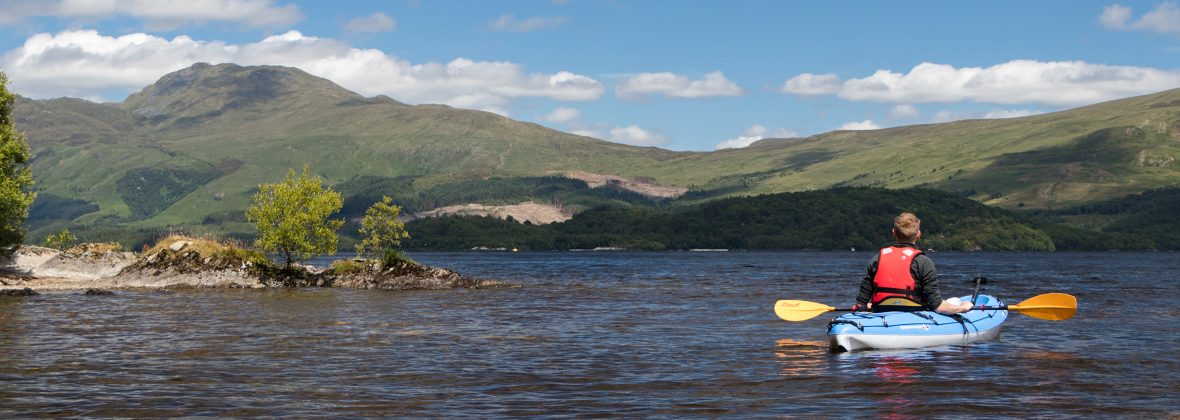 man in kayak looking over to Ben Lomond