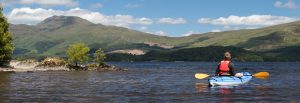 man in kayak looking over to Ben Lomond