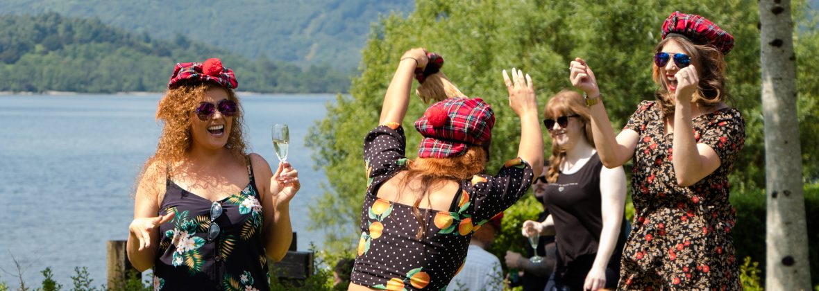 Hen party group dancing and drinking in the sun