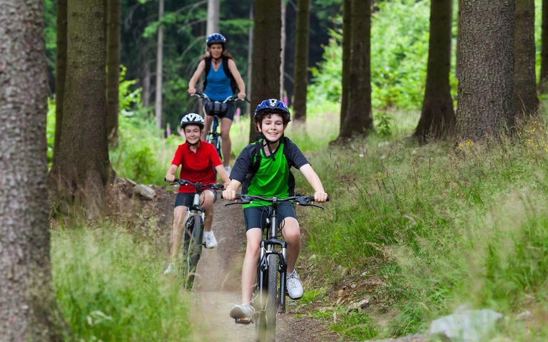 a mother and children riding bikes