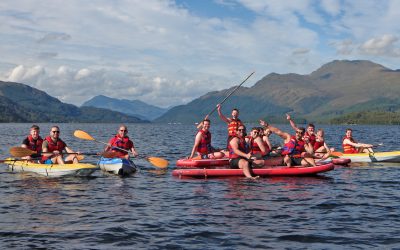 A group of people on paddlesports equipment on loch lomond