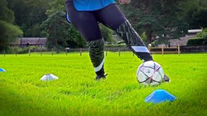 A Woman dribbling a football