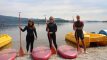 Three woman standing on the shore with paddleboards
