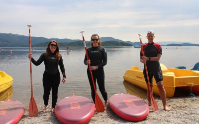 Three woman standing on the shore with paddleboards